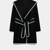 Veste longue croisée noire bordée de blanc